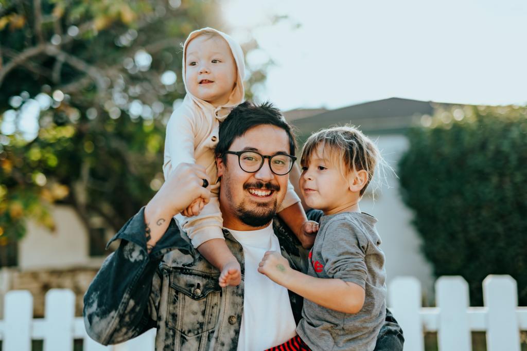 A photo of a father and his two children introduces the Bousquet Holstein family immigration practice.